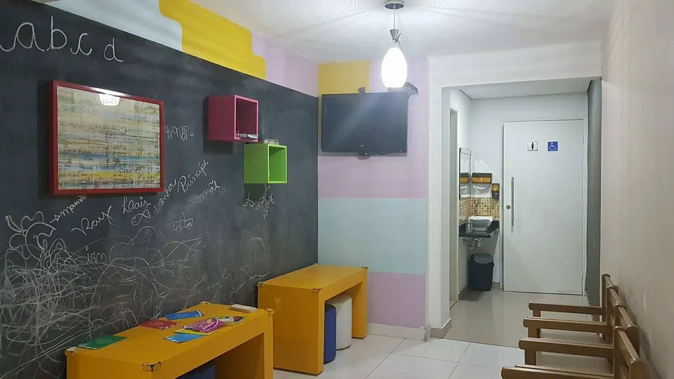 Espaço kids com lousa e mesinhas coloridas na pizzaria em Santos