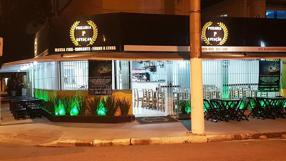 Fachada da Pizzaria Primeira Estação iluminada à noite no Canal 5, em Santos